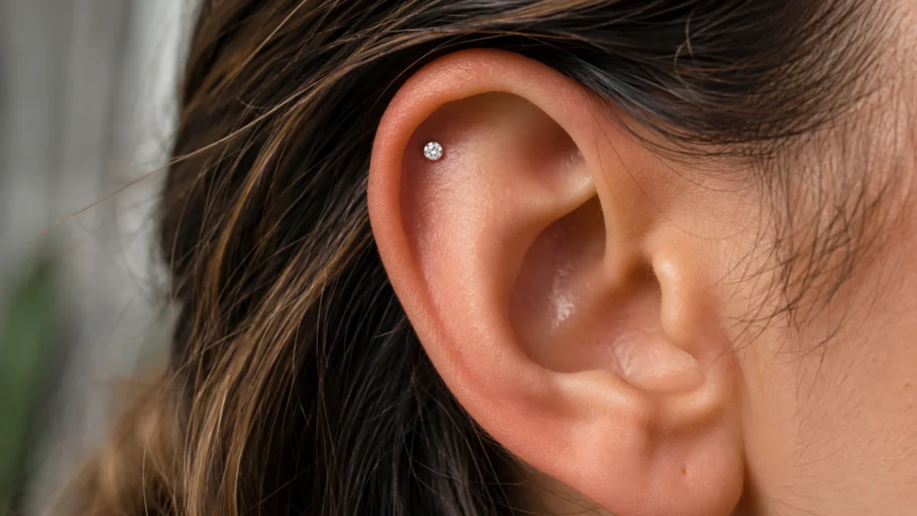 Close-up of an ear with a floating helix stud sitting flush on the upper cartilage rim