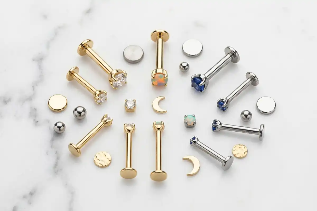 Flat lay of titanium and gold flat-back studs with small gems and discs