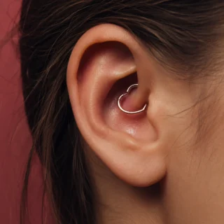 Daith, a daith piercing through the inner ear fold with a small curved ring
