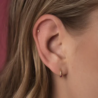 Helix, a helix piercing high on the upper ear cartilage with a small polished stud