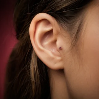 Tragus, a tragus piercing on the small flap in front of the ear canal with a tiny flat-back stud